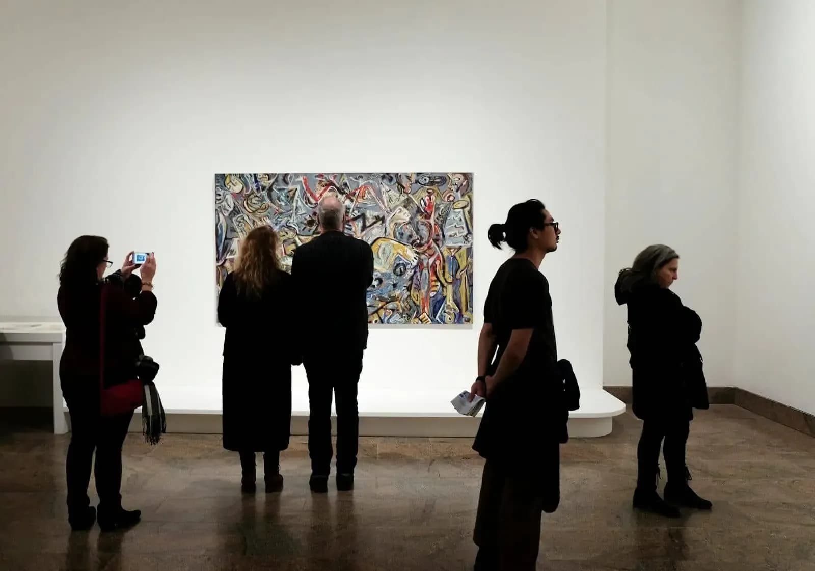 Visitantes contemplando obras en una galería de arte de Nueva York