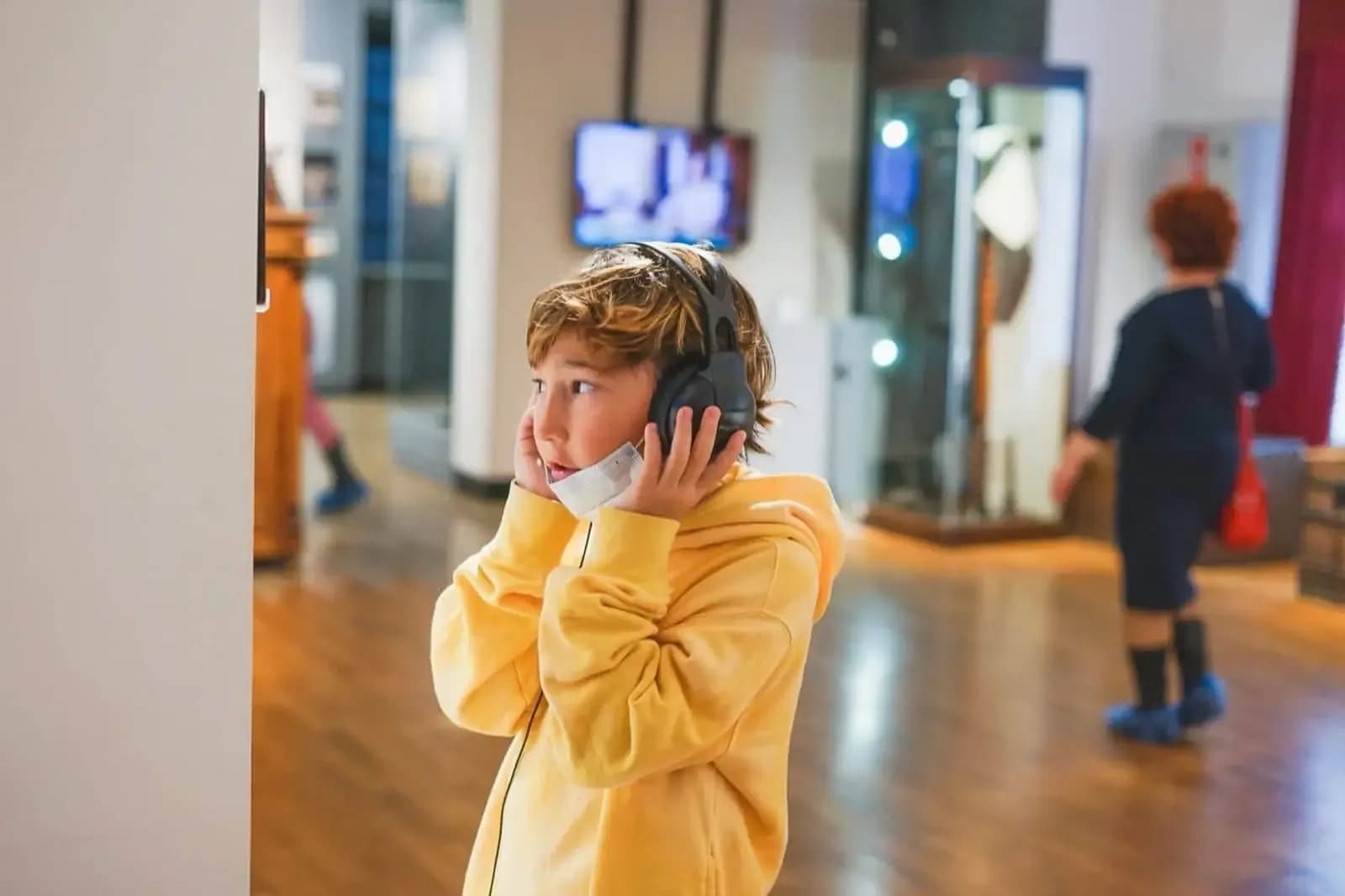 Niño escuchando una audioguía con auriculares en un museo