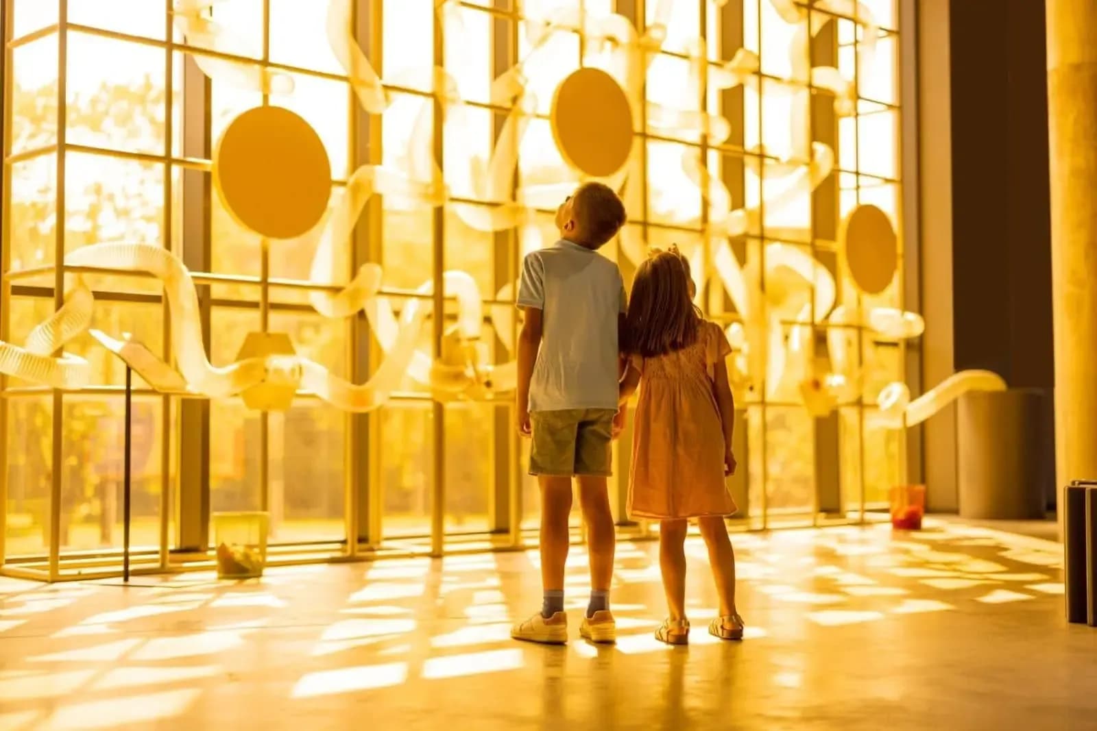 Niños observando una instalación interactiva luminosa en un museo
