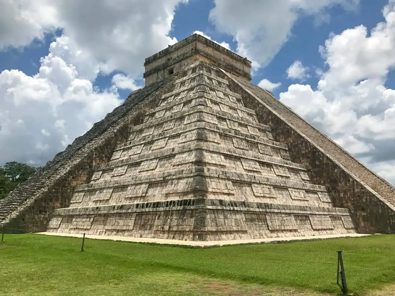 Pirámide escalonada de Chichén Itzá bajo un cielo con nubes