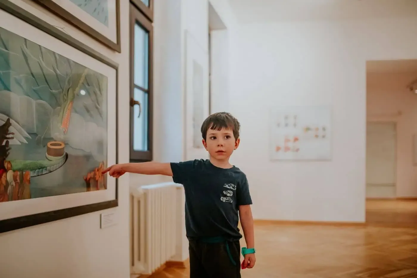 Niño señalando un cuadro en la sala de un museo